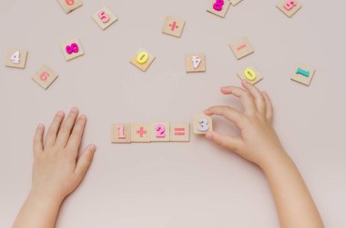 Beş yaşındaki çocuk aritmetiği ahşap sayılar kümesiyle öğreniyor..