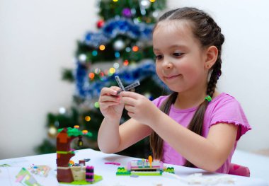 Çocuk, tatil için sunulan bir inşaatçıyı hevesle bir araya getiriyor. Bulanık, odaklanmış, seçici odaklanma. Boşluğu kopyala