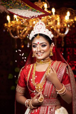 Portrait of beautiful bride in elegant wedding dress with bridal jewelry and bangle makeup with gorgeous saree studio indoor with heavy bokeh lighting. Sensuality and glamour. Portrait of beautiful adult bride in traditional bengali saree & Jewelry.