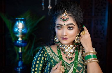 Güzel bir Müslüman gelinin portresi. Geleneksel ve muhteşem görünümlü. Yeşil Lehenga ve mücevherlerle. 