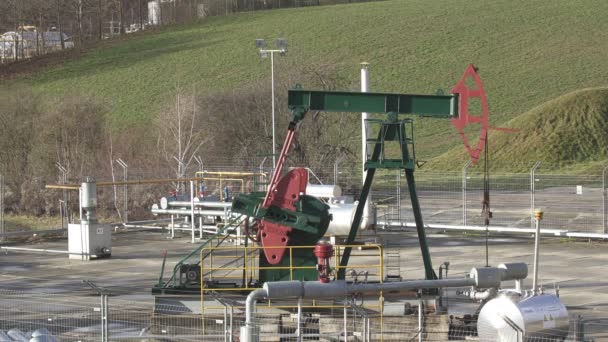 DAMBORICE, CZECH REPUBLIC, NOVEMBER 15, 2021: Pumpjack oil fracking crude extraction pump jack machine field, fossil fuel energy industry pumping unit equipment, refinery drilling mechanical machinery — Stockvideo