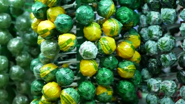 PRAAG, TSJECHIË, SEPTEMBER 25, 2021: Lollipops cannabis zoete nicy gel winkel Praag, verpakte hennepzuiger cannabidiol CBD zaden donker verlicht pijn blad symbool — Stockvideo