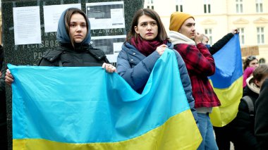 PRAGUE, CZECH Cumhuriyet, FEBRUARY 24 Şubat 2022: Ukraynalı kadın göstericiler Rus ordusuna karşı Rusya 'nın Ukraynalılara karşı savaş açmasına karşı Rusya' nın Ukraynalılara karşı yürüttüğü protesto, aktivistler bayraklara yardım