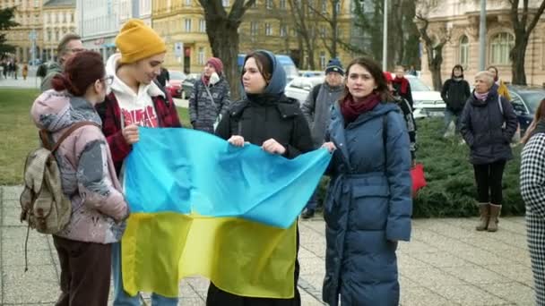 PRAGUE, CZECH Cumhuriyet, FEBRUARY 24 Şubat 2022: Ukraynalı kadın göstericiler Rus ordusuna karşı Rusya 'nın Ukraynalılara karşı savaş açmasına karşı Rusya' nın Ukraynalılara karşı yürüttüğü protesto, aktivistler bayraklara yardım — Stok video