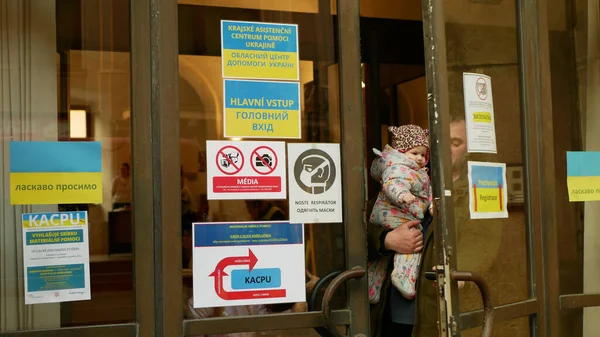 OLOMOUC, TSJECHIË, 17 maart 2022: Vluchtelingen Oekraïne kinderen familie mensen Regionale Assistentie Centrum Help Oekraïne vlag, asielverzoek, dienst humanitaire kind baby wapens loopt deur — Stockfoto