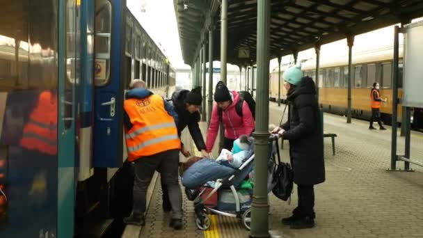BOHUMIN, CZECH REPUBLIC, MARCH 17, 2022: Refugees Ukraine children family Adra volunteer helps loading baby carriage arriving boarding people board train Bohumin station, mother bags Russia war — Stock Video