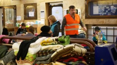BOHUMIN, CZECH REPUBLIC, 17 Mart 2022: Çocuk mülteciler Ukrayna battaniyeleri, yorgan aile treni Bohumin merkezi istasyon yardımı, anne bankta oturan bebek, valiz çantası, Rusya savaşı