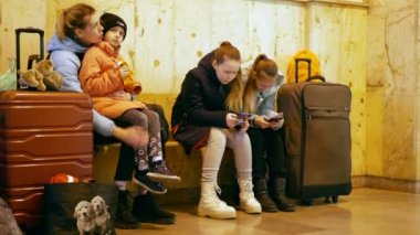 BOHUMIN, CZECH REPUBLIC, 17 Mart 2022: Mülteciler Ukraynalı çocuklar aile fertleri Bohumin merkez istasyonuna geliyor, anne bankta oturan bebek yiyor, bagaj çantası yiyor, Rusya 'dan korkuyor
