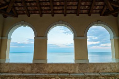 Arka planda Novigrad şehir duvarları ve Adriyatik denizi var.