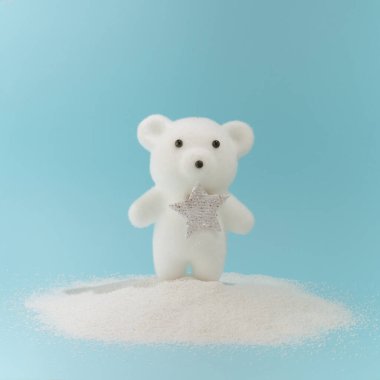 Pastel mavi arka planda karda küçük bir kutup ayısı. Asgari yaratıcı yeni yıl konsepti.