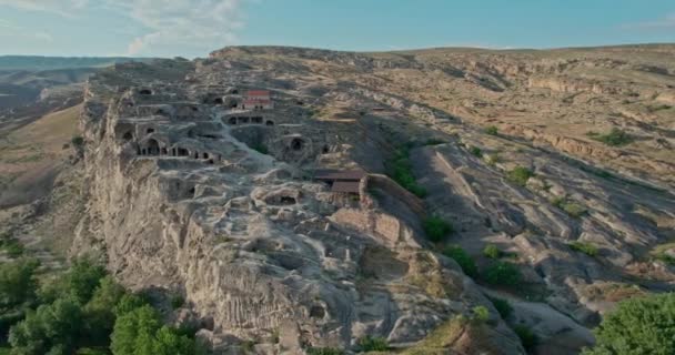 Voo de drone durante o pôr do sol sobre a antiga cidade caverna Uplistsikhe na Geórgia, local da UNESCO — Vídeo de Stock