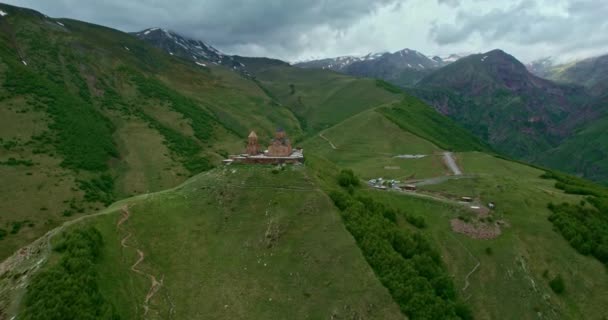 Video de la iglesia de Gergeti desde el aire sobre el fondo de las montañas — Vídeos de Stock