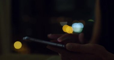 Kadın karanlık odada kıvrılabilir akıllı telefon kullanıyor