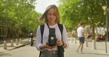 Genç bayan turist kamerada fotoğraf çekiyor.