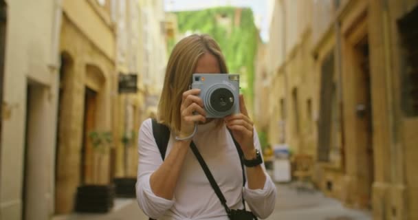 Mujer joven viaja en Europa con cámara instantánea — Vídeo de stock