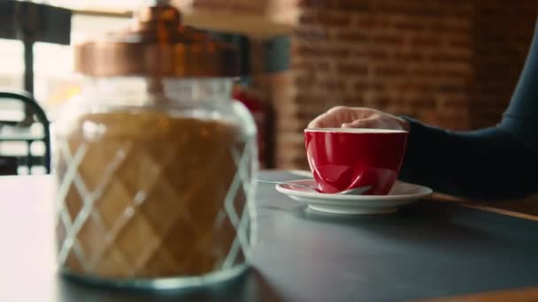 Xícara vermelha de café quente fumegante na mesa no café — Vídeo de Stock