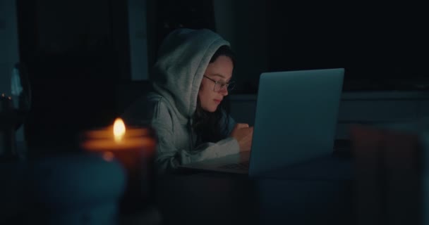 Authentieke jonge vrouw werkt op laptop in donker huis — Stockvideo