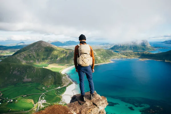 Hombre de pie en la cima de la montaña épica en Lofoten Imágenes de stock libres de derechos