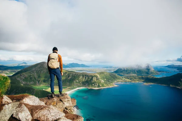 Ihminen seisoo eeppisen vuoren huipulla Lofotenissa kuvapankkikuva