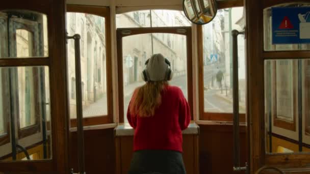 Młoda kobieta słucha muzyki w tramwaju autobusowym — Wideo stockowe