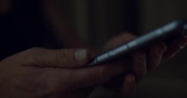 Kadın karanlık odada kıvrılabilir akıllı telefon kullanıyor