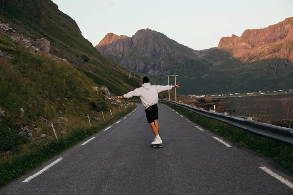 Millennial hipster man rida longboard på episk väg — Stockfoto