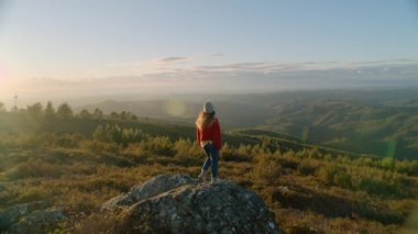 Kırmızı kazaklı kadın ellerini dağın tepesine kaldır.