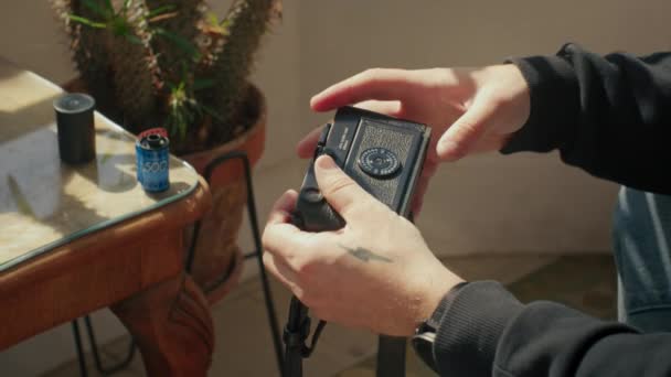 Genç adam eski model kameraya 35 mm film koymuş. — Stok video