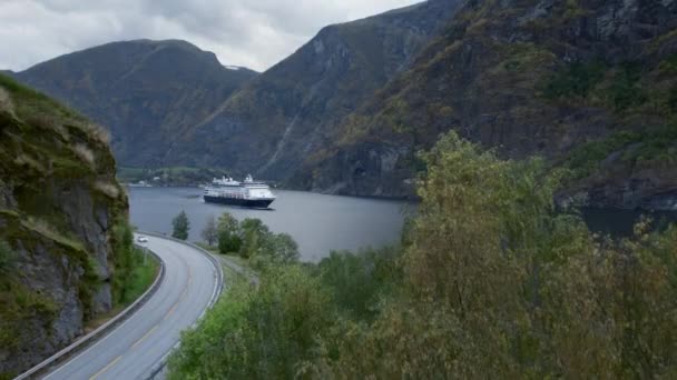 Вид с воздуха на дорогу и большой круизный корабль во фьорде — стоковое видео