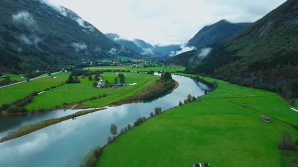 Пролетая над красивыми норвежскими землями, рекой, деревней — стоковое видео