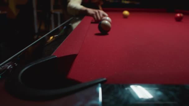 Cue in young hands hits billiard ball into hole — Stockvideo