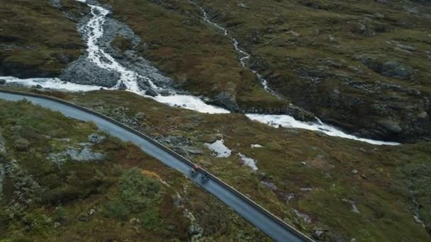 Flying drone view of cyclists riding up on road — Stockvideo