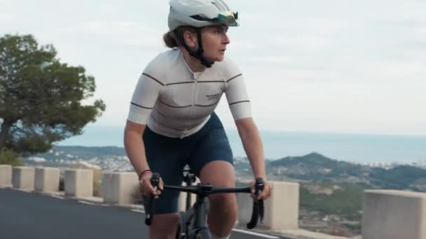 近距离观察职业公路自行车手休息 年轻精力充沛的女子骑自行车在高山路上活动困难的运动密集训练 运动员健康的室外生活方式 — 图库视频影像