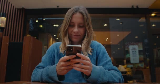 Atrakcyjna Młoda Kobieta Jasnymi Włosami Niebieskim Swetrze Siedząca Przytulnej Kawiarni — Wideo stockowe
