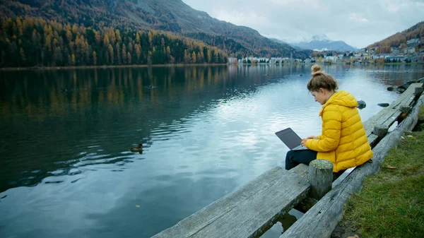 Молода Жінка Яскраво Жовтій Куртці Працює Боці Озера Своєму Ноутбуці — стокове фото
