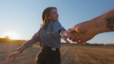 Handheld authentic shot of young woman run away from camera and look back. POV couple in love in summertime outdoor freedom in field. Commercial happiness concept. Millennial relationship lifestyle