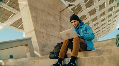 Dışarıda dizüstü bilgisayarda çalışan öğrencilerin portresi, yeni bir fikir projesi için yazı ya da kod. Park ya da şehir merkezindeki ofisten uzakta çalışan genç bir işçi. İşine odaklan. Bisikletli banliyö