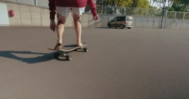 Closeup slow motion handheld footage of attractive young woman skateboarding barefoot and making sharp turn in small town. she sits low and stands up in end.Summertime youth freedom and women in sport
