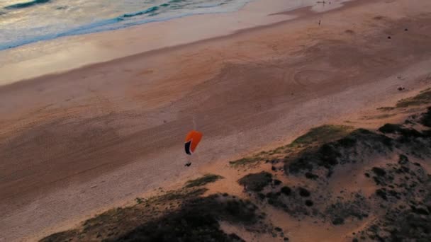 一架翼翼生机勃勃的滑翔机的空中射击 是在日落时分在靠近海洋的沙丘上空飞行 黄金时刻 天空阴云密布 Idyllic海洋景观 — 图库视频影像