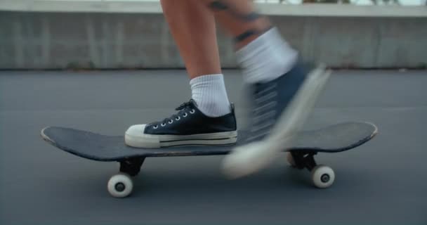女性のサイドショットは 都市部でスケートボードに乗る 若い女性スケートボーダーは 路上で速度を得るためにプッシュします スケートパーク近くのロングボードやスケートボードに乗る — ストック動画