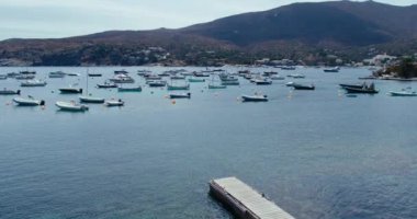 Bir sürü park etmiş balıkçı teknesi ve boş, uzun bir ahşap iskelesi olan küçük bir körfezin hayali resmi. Akdeniz kıyısında Avrupa 'da bir yerde saklı bir tatil beldesi..