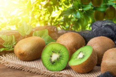 Dışarıdaki ahşap bir masada taze kiviler. Tropikal yeşil meyve yemeye hazır.