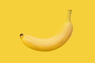Yakın plan taze muz izole ve sarı zemin üzerinde havada asılı