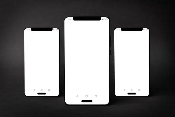 Mockup Trzech Smartfonów Odizolowanych Czarnym Tle Teksturowanym Cieniami — Zdjęcie stockowe