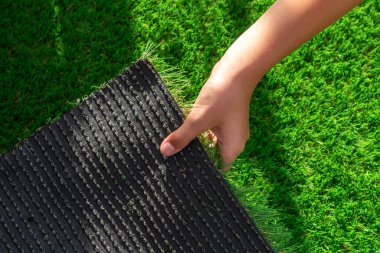 Close-up of the back of a roll of artificial turf. Synthetic artificial grass material easy to install and maintain