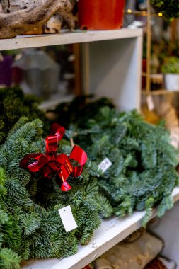 Noel arifesinde doğal ladin iğneleri ve kırmızı kurdeleli orijinal Noel çelengi satışı