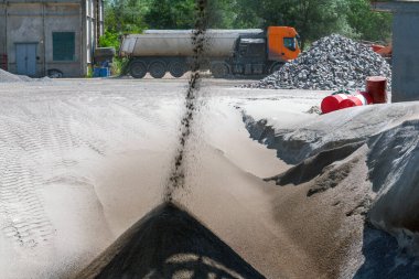 Taşıyıcı banttan küçük granit ezilmiş taş dökülüyor. Taş ocağında maden ocağında granit çakıl taşı. Ezilmiş taş ve çakıl işleme tesisi. Madencilik ve Madencilik ekipmanları.