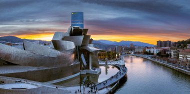 Bilbao, İspanya - NOV 20, 2021: Frank Gehry tarafından tasarlanan Guggenheim Müzesi 'nin muhteşem akşam panoramik manzarası ve Bilbao seddi Estuary ve IBERDROLA enerji şirketinin gökdeleni