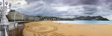 San Sebastian, İspanya - NOV 21, 2021: San Sebastian, Donostia, Gipuzkoa, Bask Ülkesi 'nin eski kasaba merkezinde La Concha kumsalı ve Santa Clara Adası' nın dramatik sonbahar panoramik manzarası