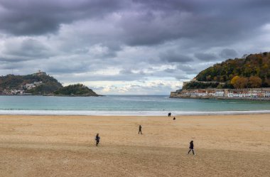San Sebastian, Donostia, Gipuzkoa, Bask Bölgesi 'nin eski kasaba merkezinde La Concha kumsalı ve Santa Clara Adası' nın dramatik sonbahar panoramik manzarası - İspanya 'da sıcak kış